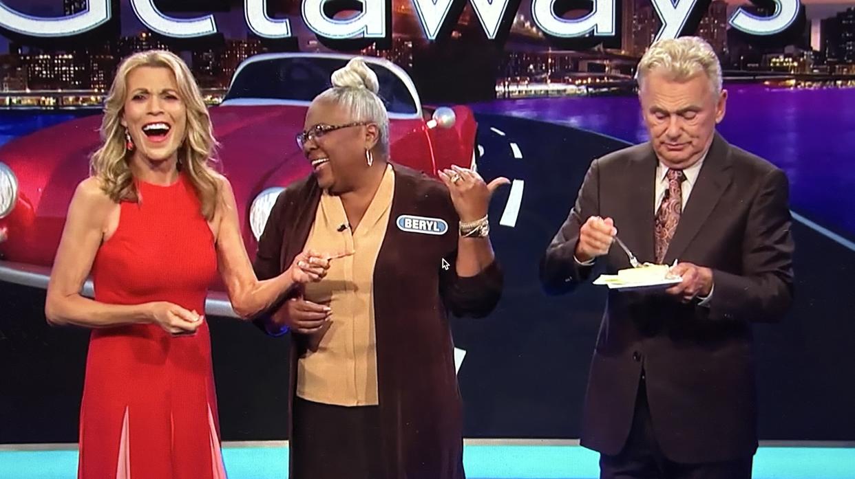 Pat Sajak intercepts a piece of cake gifted from Vanna White to contestant Beryl New. (ABC)
