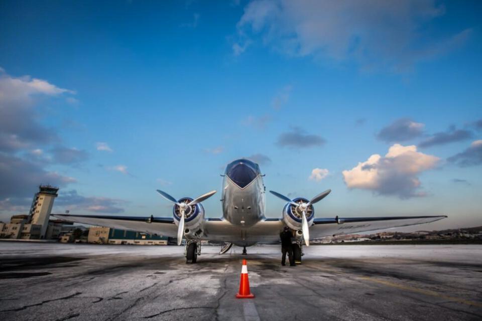 Check out the price differences between these Trusted Traveler Programs. Pictured: front view of a propeller plane on the tarmac.