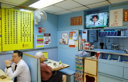 A man watches a TV broadcast of news conference of Hong Kong Chief Executive Carrie Lam inside a restaurant in Hong Kong