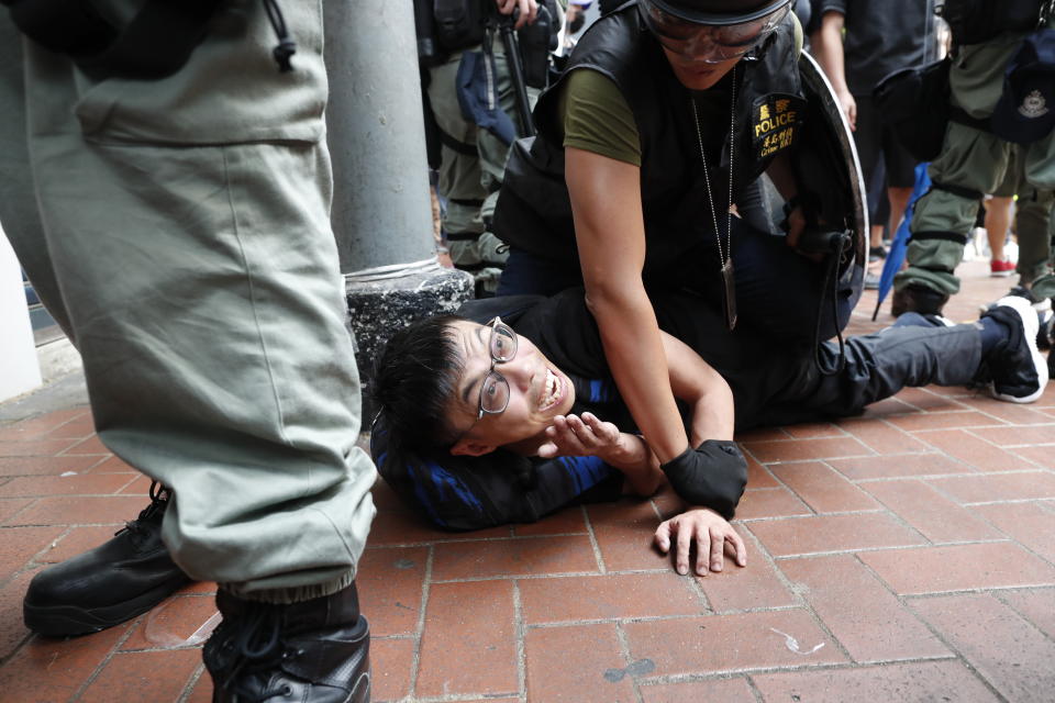 Police detain a protestor in Hong Kong, Sunday, Sept. 29, 2019. Police on Saturday fired tear gas and water cannons after protesters threw bricks and firebombs at government buildings following a massive rally in downtown Hong Kong. The clashes were part of a familiar cycle since protests began in June over a now-shelved extradition bill and have since snowballed into an anti-China movement with demands for democratic reforms. (AP Photo/Gemunu Amarasinghe)