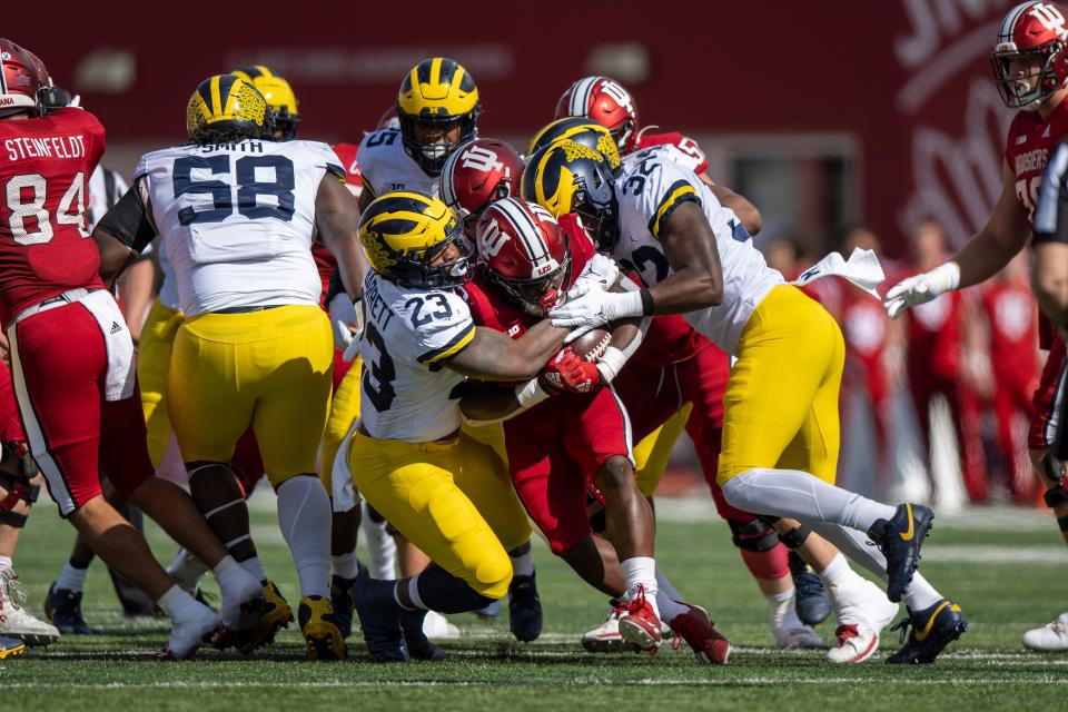 Indiana running back Shaun Shivers (center) is tackled by Michigan Wolverines linebacker Michael Barrett (23) and Michigan Wolverines linebacker Jaylen Harrell (32) during first quarter Oct. 8, 2022 against Indiana at Memorial Stadium in Bloomington.