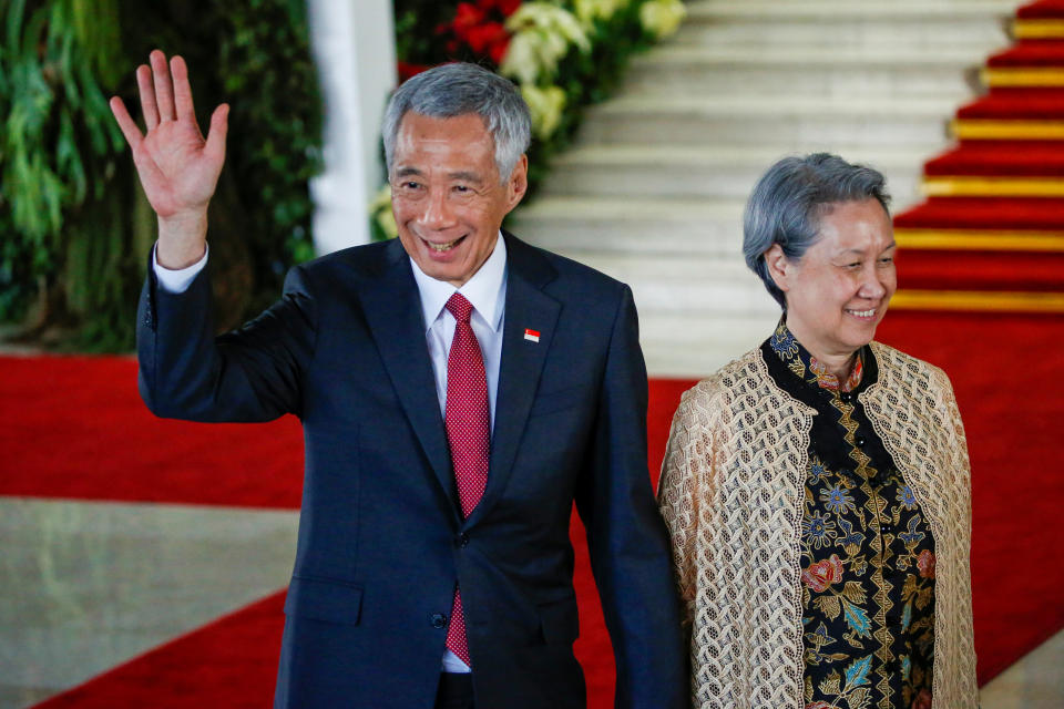 Singapore&#39;s Prime Minister Lee Hsien Loong waves as he walks with his wife Ho Ching after attending the inauguration of Indonesia&#39;s President Joko Widodo for the second term, at the House of Representatives building in Jakarta, October 20, 2019. REUTERS/Willy Kurniawan