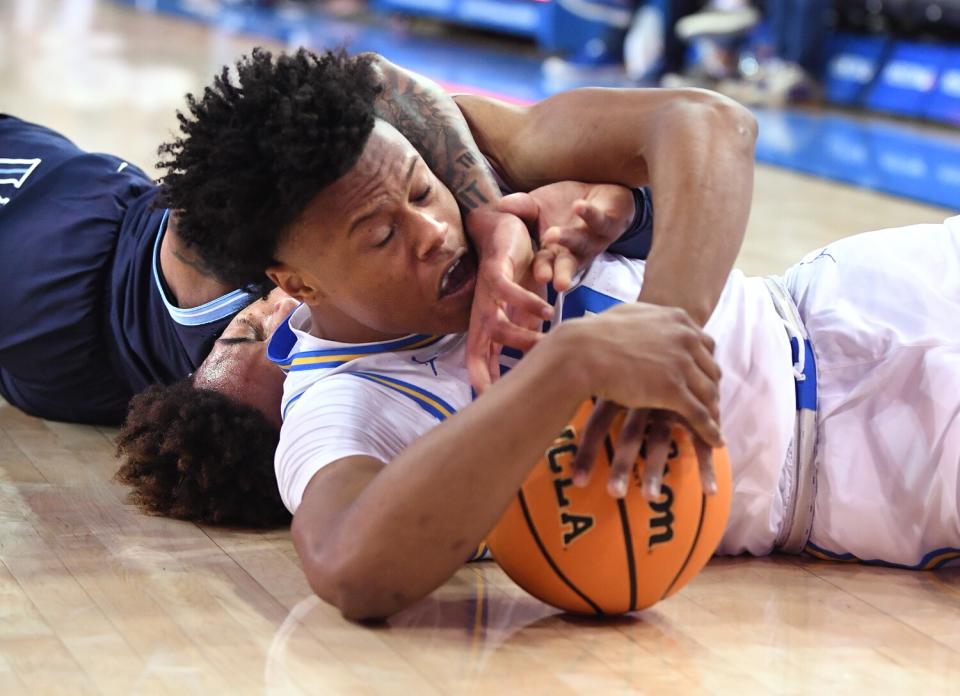 UCLA's Jaylen Clark battles Villanova's Justin Moore for a loose ball during the Bruins' overtime win Friday.