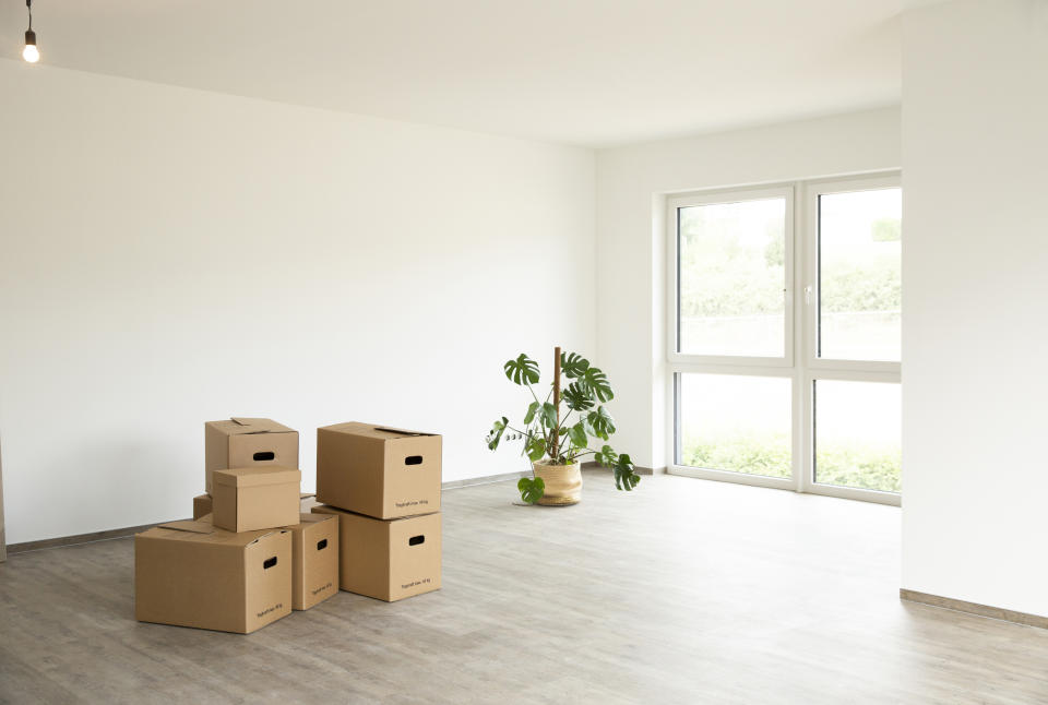 Empty room with unpacked boxes, highlighting moving into a new apartment