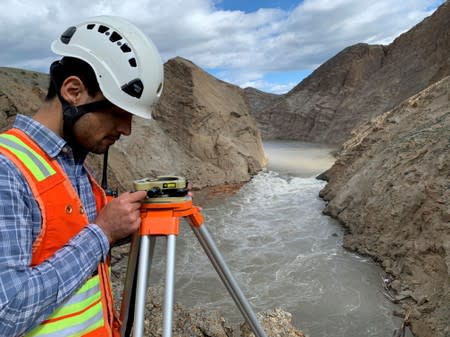 Part of the crew tackling the Big Bar landslide uses an instrument on a bluff overlooking the Fraser River