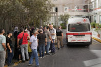 CORRECTS DAY TO TUESDAY WHEN INJURED Lebanese Red Cross ambulance passes next of the families of victims who were injured on Tuesday by their exploding handheld pagers, at the emergency entrance of the American University hospital, in Beirut, Lebanon, Wednesday, Sept. 18, 2024. (AP Photo/Hussein Malla)