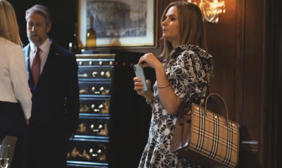 Big and baggy: A large Burberry tote bag on the shoulder of Cousin Greg’s date to Logan’s birthday party (HBO)