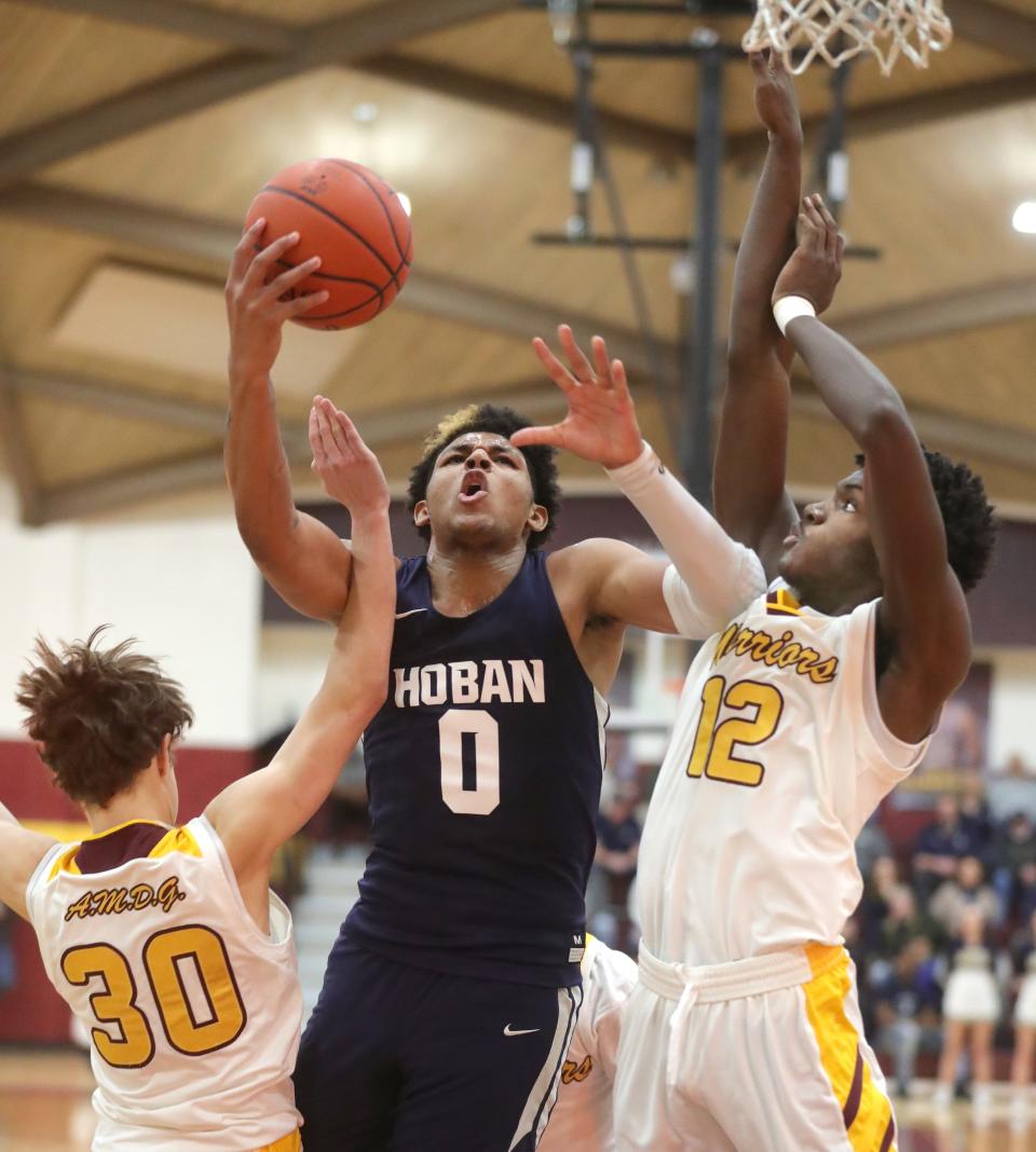 Hoban's Jonas Nichols puts up a shot inside between Walsh Jesuit's Tyler Bell, left, and Keith Rivers on Tuesday, Jan. 25, 2022 in Cuyahoga Falls.