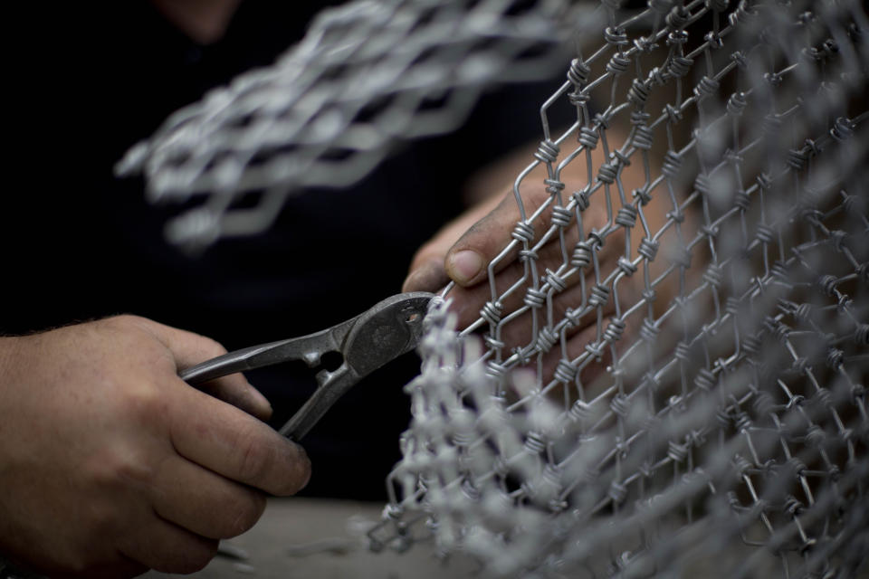 In this Saturday, Nov 2, 2019 photo, Palestinian artist Haitham Khateeb makes art objects depicting Palestinian daily life, at his house in the West Bank village of Bilin near Ramallah. After 14 years as a photographer in the Israeli-occupied West Bank, Khateeb has found his second calling through sculpture, telling stories by recycling metal wire into art. (AP Photo/Majdi Mohammed)