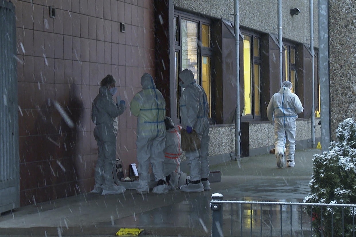 Investigators stand outside a building used by Jehovah's Witnesses in Hamburg, Germany, Friday, March 10, 2023. Shots were fired inside the building used by Jehovah's Witnesses in the northern German city of Hamburg on Thursday evening, with multiple people killed and wounded, police said. (Steven Hutchings/Tnn/dpa via AP)