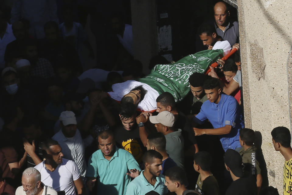 Mourners and relatives carry the body of Mohammed Abu Ammar outside the main mosque during his funeral in Bureij refugee camp, central Gaza Strip, Thursday, Sept. 30, 2021. Israeli troops shot and killed Abu Ammar, a 40-year-old Palestinian, on Thursday as he was setting bird traps in the Gaza Strip near the Israeli border, his family said. The military said it was investigating. (AP Photo/Adel Hana)