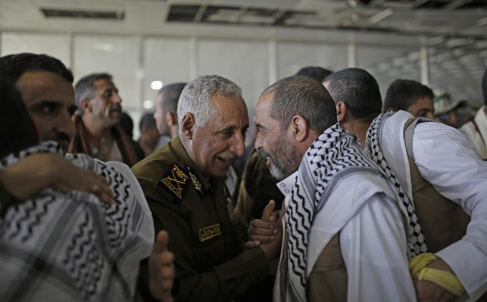 Yemeni prisoners are greeted by Houthi officers during their arrival after being released by the Saudi-led coalition in the airport of Sanaa, Yemen, Thursday, Nov. 28, 2019. The International Committee of the Red Cross says over a hundred rebel prisoners released by the Saudi-led coalition have returned to Houthi-controlled territory in Yemen, a step toward a long-anticipated prisoner swap between the warring parties. (AP Photo/Hani Mohammed)