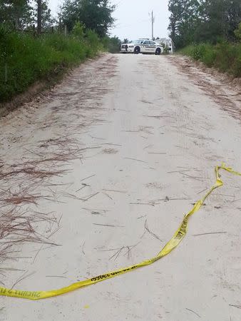 A Sheriff's patrol vehicle blocks the road leading to the scene of a murder-suicide that left eight people dead on Thursday in Bell, Florida, September 19, 2014. REUTERS/Barbara Liston