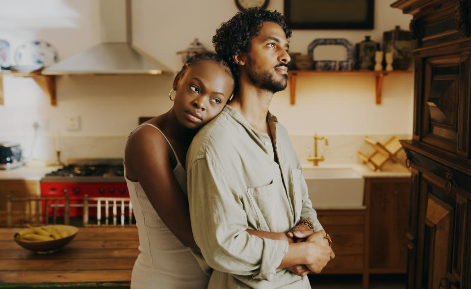 a man and a woman looking sad inside home