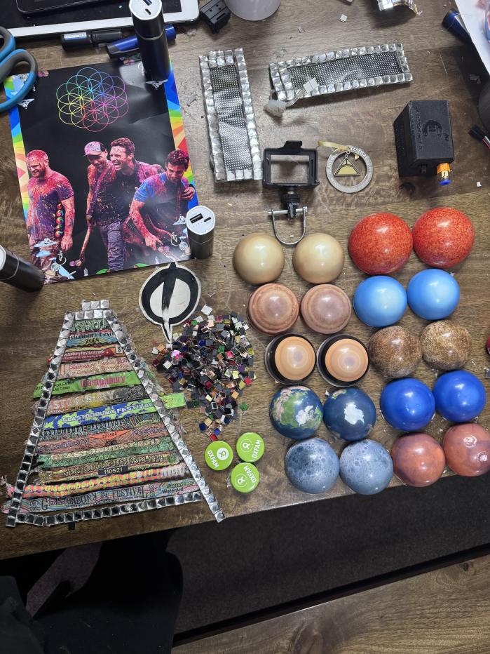 A view of the pieces of the hat, including a picture of Coldplay and Alex McGuire's wristbands from the festival in previous years