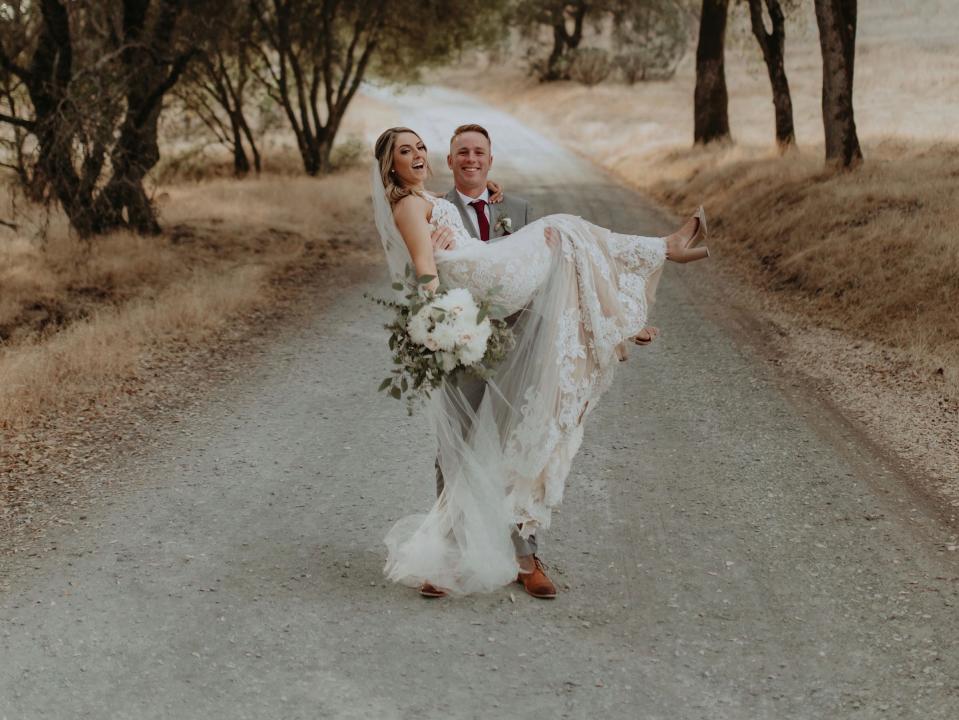 Shannon Detrick being held by her groom.