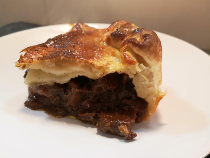 a slice of steak pie on a white plate