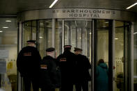 Police officers walk in the main entrance of St Bartholomew's Hospital in London, where Britain's Prince Philip is being treated, Wednesday, March 3, 2021. Buckingham Palace said Philip, the 99-year-old husband of Queen Elizabeth II, was transferred from King Edward VII's Hospital to St Bartholomew's Hospital on Monday to undergo testing and observation for a pre-existing heart condition as he continues treatment for an unspecified infection. (AP Photo/Matt Dunham)