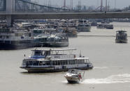 In this photo taken on Wednesday, June 5, 2019, sightseeing, restaurant and tour boats are seen on the Danube River near the Elizabeth Bridge in Budapest. A tourism boom in the Hungarian capital has led to major congestion on the river flowing through the city, with sightseeing boats and floating hotels competing for better positions in front of spectacular neo-Gothic buildings, ornate bridges and churches lining the Danube. (AP Photo/Laszlo Balogh)