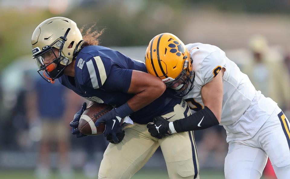 Hoban wide receiver Jayvian Crable, left, is brought down after a short gain by St. Ignatius defensive back Ben Taliak during the first half of a high school football game, Friday, Sept. 16, 2022, in Akron, Ohio.