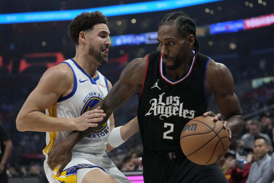 Golden State Warriors guard Klay Thompson, left, defends against Los Angeles Clippers forward Kawhi Leonard (2) during the first half of an NBA basketball game in Los Angeles, Saturday, Dec. 2, 2023. (AP Photo/Ashley Landis)