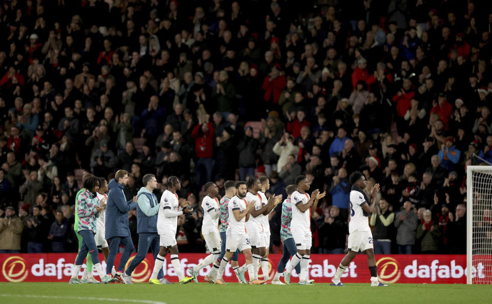 Luton Town's players applaud the fans as they make their way around the stadium after the game was abandoned following the collapse of their team mate Tom Lockyer, during the English Premier League soccer match between Bournemouth and Luton Town at the Vitality Stadium, in Bournemouth, England, Saturday, Dec. 16, 2023. (Steven Paston/PA via AP)