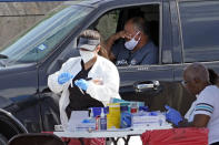 A patient reacts after a healthcare worker collected a sample at a United Memorial Medical Center COVID-19 testing site Thursday, July 16, 2020, in Houston. (AP Photo/David J. Phillip)