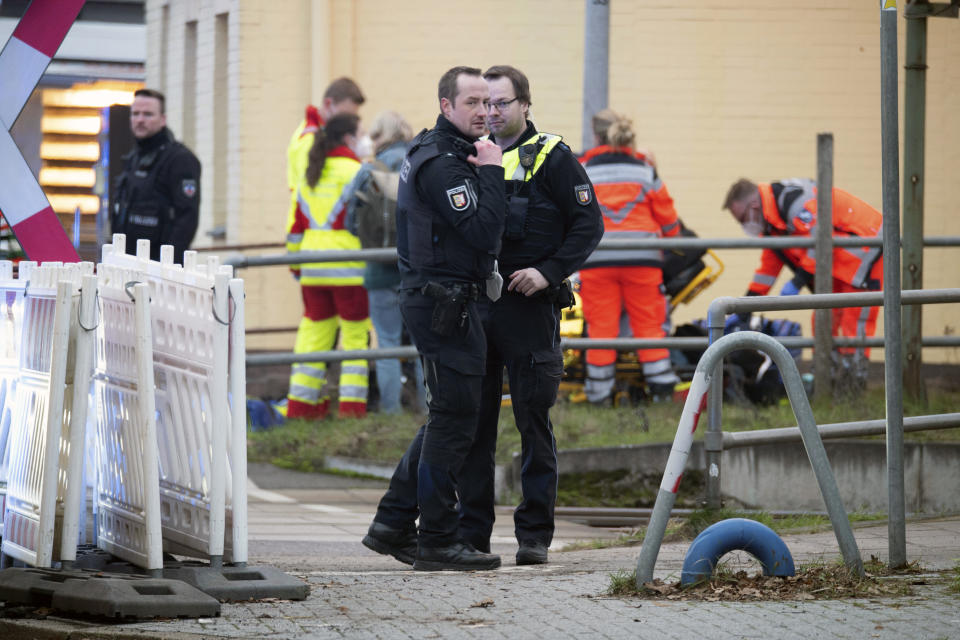 Police officers stand guard as emergency services work at Brokstedt station in Brockstedt, Germany, Wednesday, Jan. 25, 2023. A man stabbed and wounded several people on a train in northern Germany on Wednesday before police detained him, and two of the victims died, German news agency dpa reported. (Jonas Walzberg/dpa via AP)