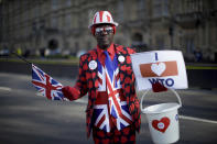 Un partidario de que Gran Bretaña abandone la Unión Europea, Joseph Afrane, un ghanés de 55 años de Londres, posa para una fotografía ante el Palacio de Westminster, en Londres, el 14 de febrero de 2019. Joseph cree que dejar la UE sin un acuerdo de divorcio sería la mejor forma de seguir adelante. El colorido debate rebasó los muros de la Cámara de los Comunes, hasta los terrenos aledaños al parlamento, que son, tradicionalmente, un escaparate de ideas, protestas y mítines. (AP Foto/Matt Dunham)