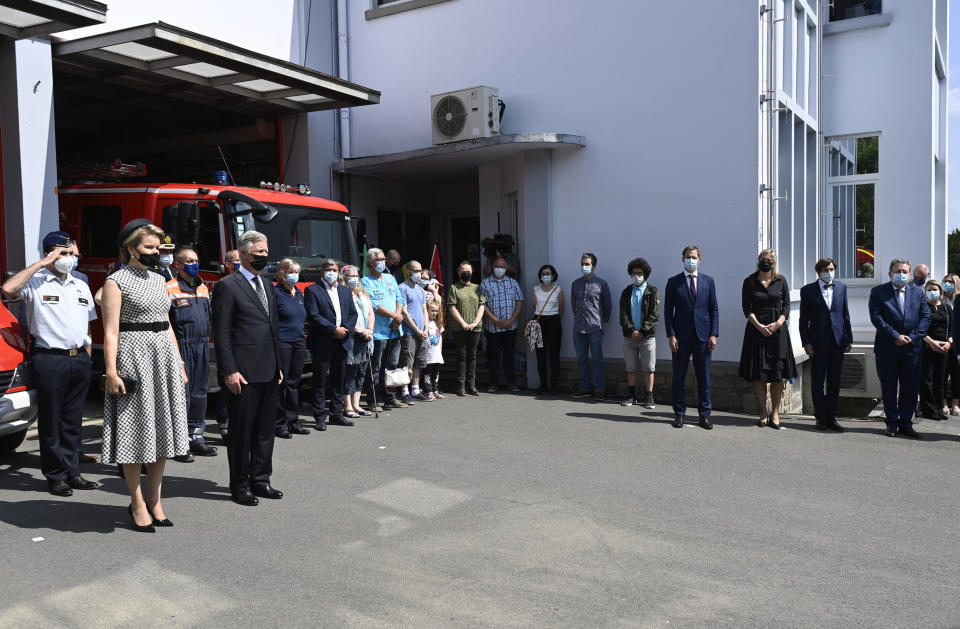 Belgium's King Philippe, fifth left, and Belgium's Queen Mathilde, second left, and Belgium's Prime Minister Alexander De Croo, center, stand with victims and emergency workers during one minute of silence to pay respect to victims of the recent floods in Belgium, in Verviers, Belgium, Tuesday, July 20, 2021. Belgium is holding a day of mourning on Tuesday to show respect to the victims of the devastating flooding last week, when massive rains turned streets in eastern Europe into deadly torrents of water, mud and flotsam. (Eric Lalmand, Pool Photo via AP)