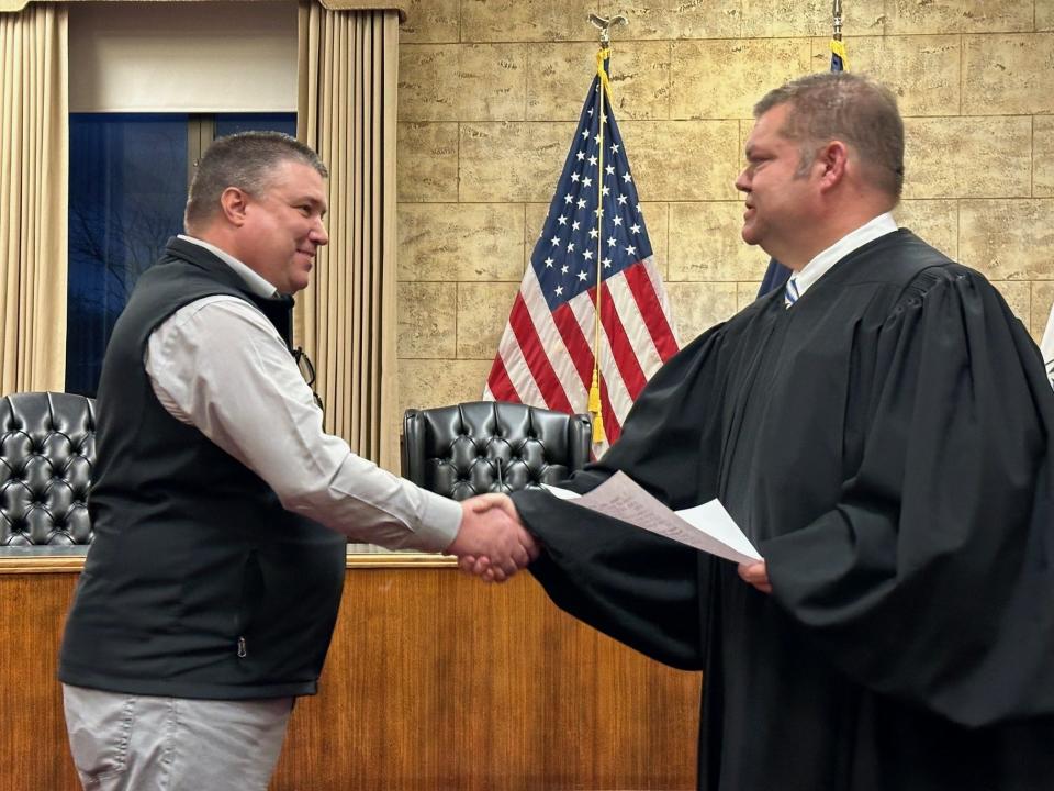 Newly elected Mayor Cory Reeves (left) is congratulated by Municipal Court Judge Steven Bolstad after taking the oath of office Tuesday night