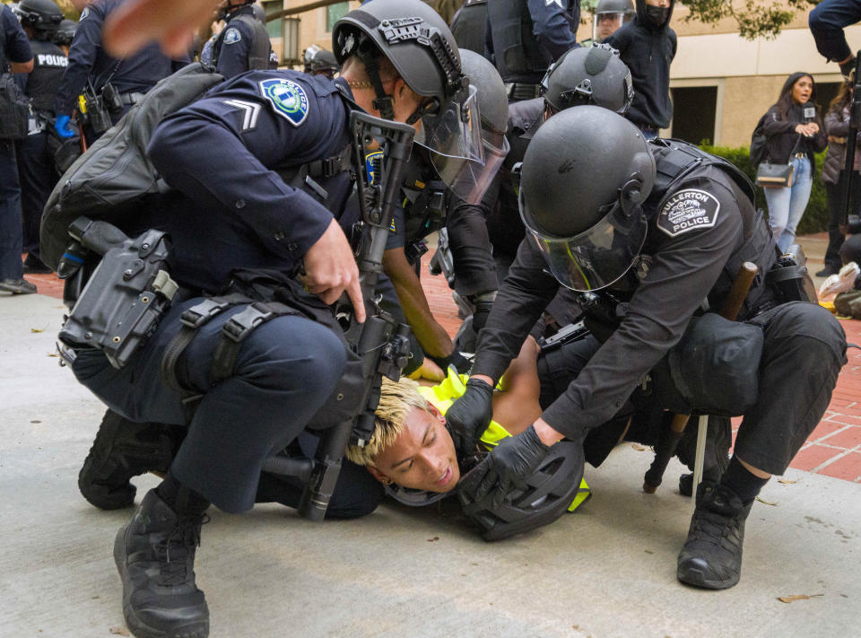 Police wrestle a pro-Palestinian protester to the ground to put wrist restraints on him at the University of California, Irvine, after police began to move protesters and an encampment off the quad, Wednesday, May 15, 2024, in Irvine, Calif. (Leonard Ortiz/The Orange County Register via AP)