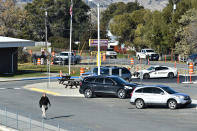 CORRECTS TO SAY WHAT AUTHORITIES THOUGHT WERE THE REMNANTS OF AN EXPLOSIVE DEVICE TURNED OUT TO BE NONEXPLOSIVE MATERIALS - The Lewis and Clark County bomb squad works the scene at Rossiter Elementary School in Helena, Mont., Tuesday, Oct. 15, 2019, after authorities found what they thought were the remnants of an improvised explosive device on the school playground. Authorities evacuated the elementary school in Montana's capital city Tuesday after officials found the unknown materials, but they turned out to be a plastic bottle filled with nuts and bolts left in the schoolyard. (Thom Bridge/Independent Record via AP)