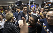 Thailand's Future Forward Party leader Thanathorn Juangroongruangkit shakes hands with supporters at the party's headquarters in Bangkok, Thailand, Tuesday, Jan. 21, 2020. Thailand's Constitutional Court acquitted the country's third-biggest political party of seeking the overthrow of the country's constitutional monarchy. The court ruled Tuesday that the Future Forward Party showed no intention of committing the offense, and that the complaint had not been filed according to the correct legal procedure. (AP Photo/Sakchai Lalit)