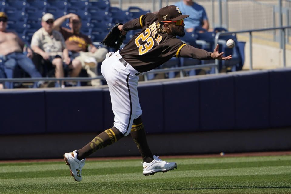 RETRANMISSION TO CORRECT LOCATION TO PEORIA - San Diego Padres shortstop Fernando Tatis Jr. reaches for a ground ball hit for a single by Oakland Athletics's Kai'ai Tom in the third inning of a spring training baseball game Thursday, March 18, 2021, in Peoria, Ariz. (AP Photo/Sue Ogrocki)