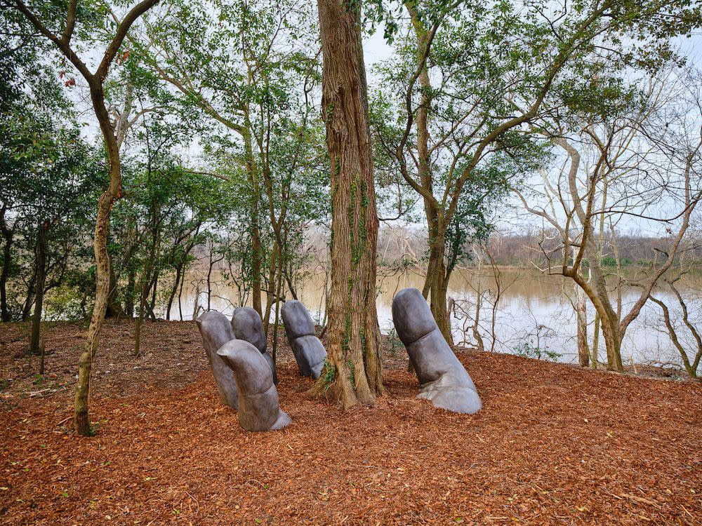 a group of statues sit in a park