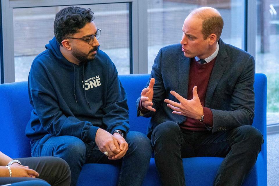 Prince William, Prince of Wales (R) speaks with support worker Faizaan Hamid during his visit to Together as One