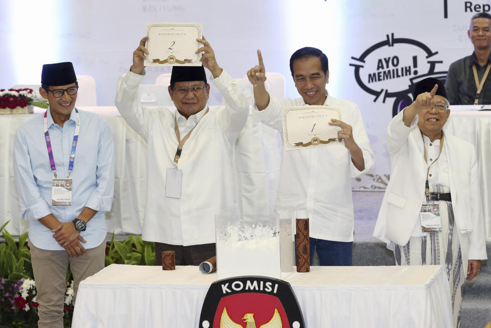 FILE - In this Sept. 21, 2018, file photo, Indonesian presidential candidates Prabowo Subianto, second from left, and his running mate Sandiaga Uno, left, Joko Widodo, second from right, and his running mate Ma'ruf Amin, show the ballot numbers that will represent them in the upcoming presidential election, during a draw at the General Election Commission office in Jakarta, Indonesia. Indonesia's presidential election Wednesday, April 17, 2019 is a re-run of the 2014 contest when Widodo, a furniture business owner who became Jakarta governor, vied with the former special forces general to lead the world's third-largest democracy and most populous Muslim-majority nation. (AP Photo/Achmad Ibrahim, File)