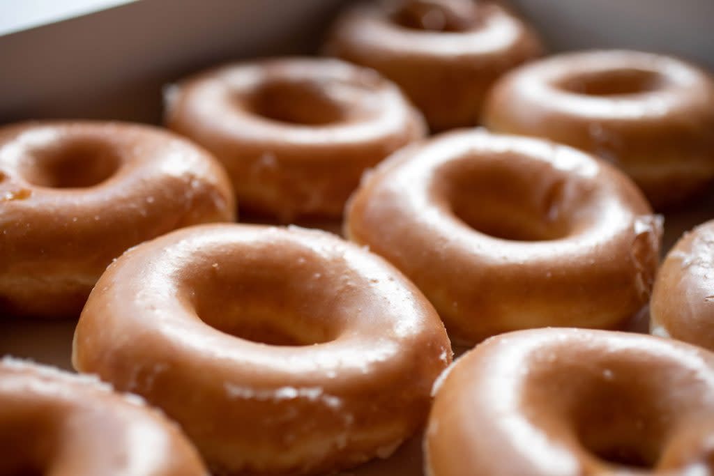 Krispy Kreme doughnuts sit in a box. 