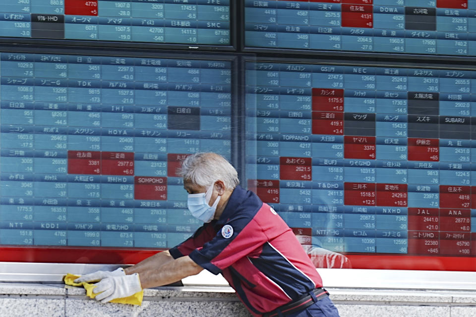 FILE - A custodian cleans up an electronic stock board showing Japan's Nikkei index at a securities firm in Tokyo, on Aug. 26, 2024. (AP Photo/Eugene Hoshiko, File)