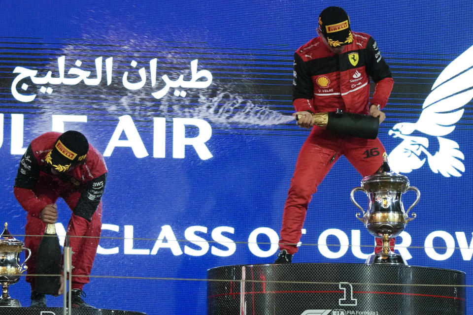 First placed Ferrari driver Charles Leclerc of Monaco, right, and second placed Ferrari driver Carlos Sainz of Spain celebrate on the podium after the Formula One Bahrain Grand Prix it in Sakhir, Bahrain, Sunday, March 20, 2022. (AP Photo/Hassan Ammar)