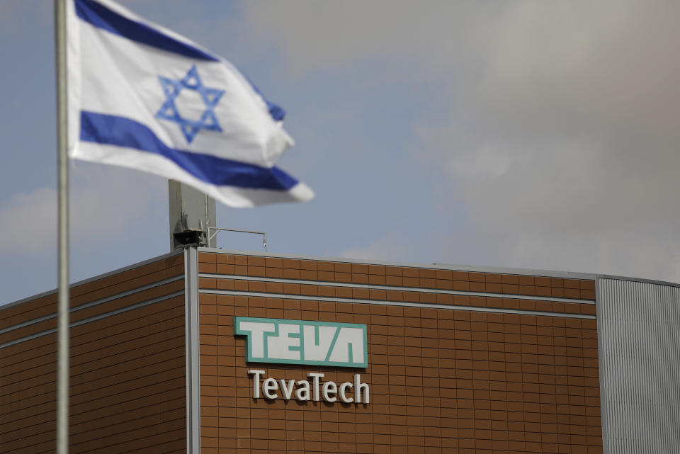 FILE - In this Dec. 14, 2017 file photo, an Israeli flag flies outside a Teva Pharmaceutical Industries building, in Neot Hovav, Israel. On Thursday, Nov. 1, 2018, Israeli drug maker Teva reported a third-quarter loss as it proceeds with an aggressive cost-cutting program and adjusts to declines in key product categories. But the company gave an upbeat outlook, citing stabilization in its core generics business, the launch of new products and progress with its restructuring program. Its stock price surged on the news. (AP Photo/Tsafrir Abayov, File)