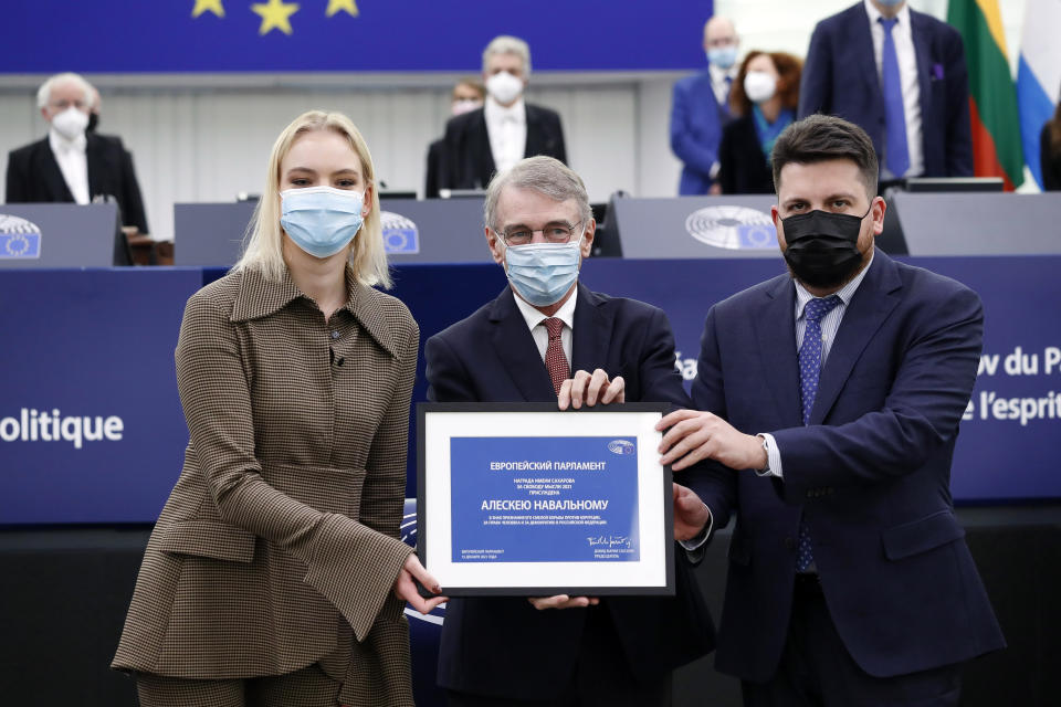 Daria Navalnaya, the daughter of jailed Russian opposition leader Alexei Navalny, left, European Parliament President David Sassoli, center, and Russia's Leonid Volkov, Chief of staff for the 2018 presidential election for Alexei Navalny's campaign, right, during the Award of the Sakharov Prize ceremony at the European Parliament in Strasbourg, eastern France, Wednesday, Dec. 15, 2021. Daria Navalnaya receives the Sakharov Prize for Freedom of Thought Award, the European Union top human rights prize, on behalf of her father. (Julien Warnand, Pool Photo via AP)