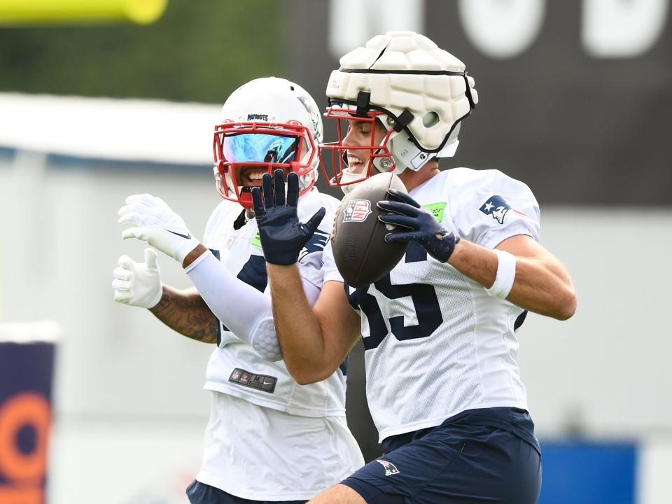 July 29: New England Patriots tight end Hunter Henry (85) and wide receiver Kendrick Bourne react after a drill.