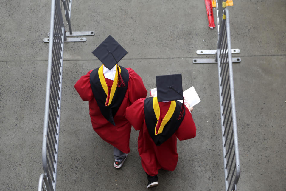 FILE - New graduates walk into the High Point Solutions Stadium before the start of the Rutgers University graduation ceremony in Piscataway Township, N.J., on May 13, 2018. President Joe Biden’s student loan cancellation offers a life-changing financial break for millions of Americans. But for future students heading to college under the same conditions that created today’s debt, critics say it offers little help. Chief among the causes of today's rising student debt is the cost of college. (AP Photo/Seth Wenig, File)