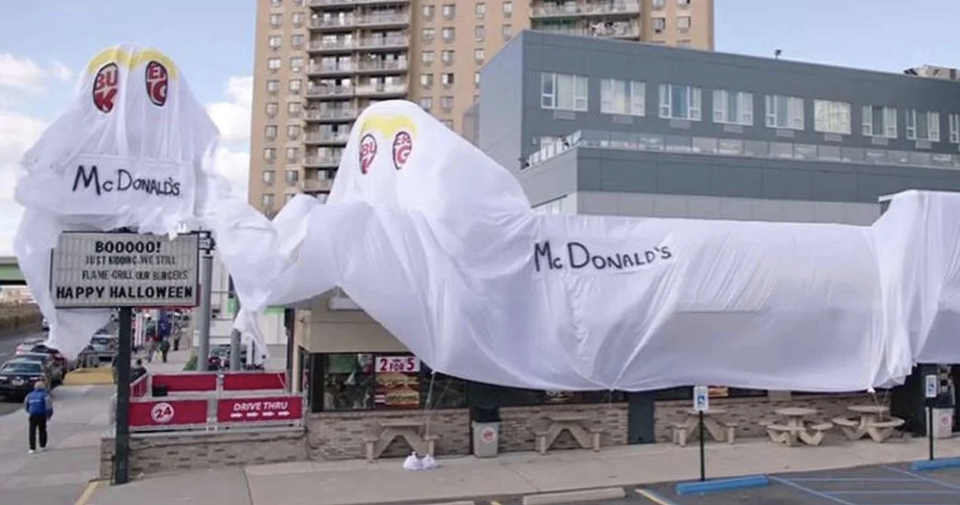 A white plastic cover with "McDonald's" written on it covering the Burger King restaurant, with "eyes" showing part of the Burger King logo