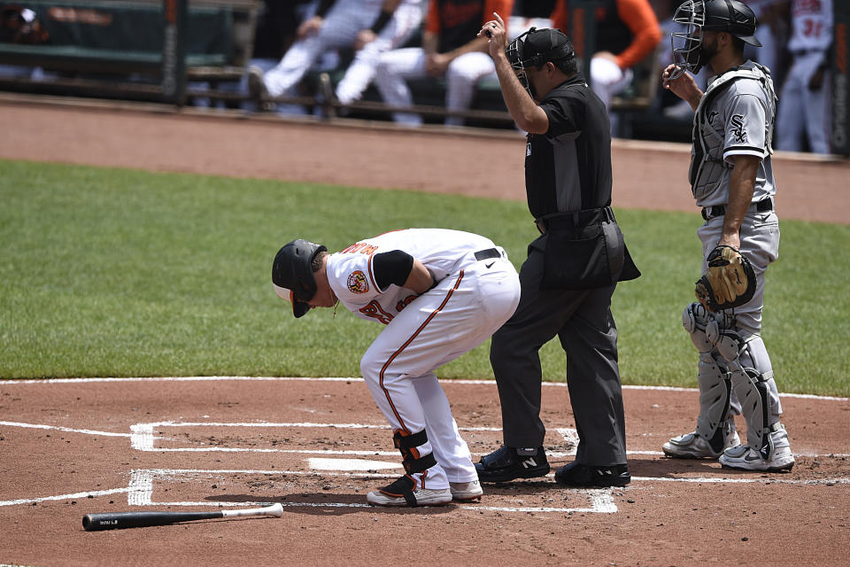 Baltimore Orioles' Ryan Mountcastle, left, reacts after getting hit on the hand by a pitch in the first inning of a baseball game against the Chicago White Sox, July 11, 2021 in Baltimore.(AP Photo/Gail Burton)