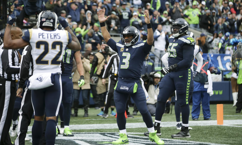 Seattle Seahawks quarterback Russell Wilson signals a touchdown after passing to wide receiver David Moore (not shown) early in the third quarter of an NFL football game against the Los Angeles Rams, Sunday, Oct. 7, 2018, in Seattle. (AP Photo/Scott Eklund)