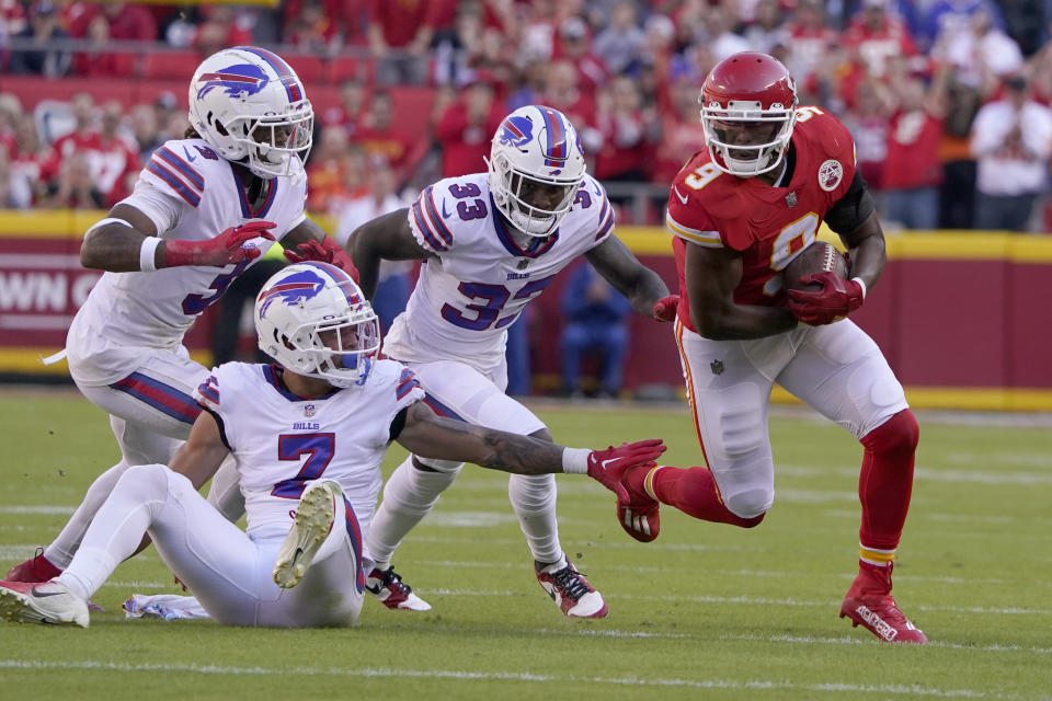 Kansas City Chiefs wide receiver JuJu Smith-Schuster (9) slips past Buffalo Bills safety Damar Hamlin (3), cornerback Taron Johnson (7) and cornerback Siran Neal (33) on his way to a touchdown during the first half of an NFL football game Sunday, Oct. 16, 2022, in Kansas City, Mo. (AP Photo/Ed Zurga)