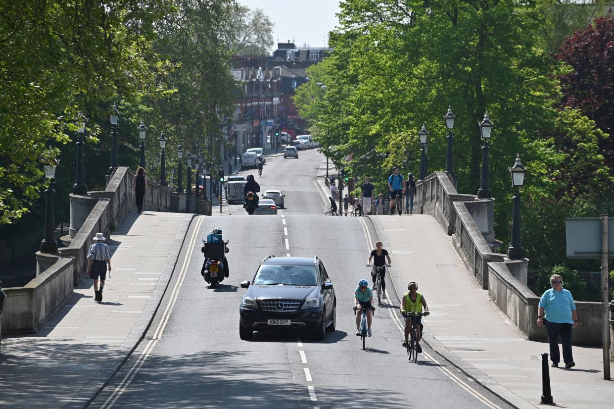 A car overtakes cyclists in Richmond, south west London on April 23, 2020 during the lockdown aimed at halting the spread of the novel coronavirus COVID-19 PANDEMIC. - Britain's health ministry on Thursday said 616 more people had died after testing positive for the novel coronavirus in hospital, taking the country's official death toll to 18,738. (Photo by JUSTIN TALLIS / AFP) (Photo by JUSTIN TALLIS/AFP via Getty Images)